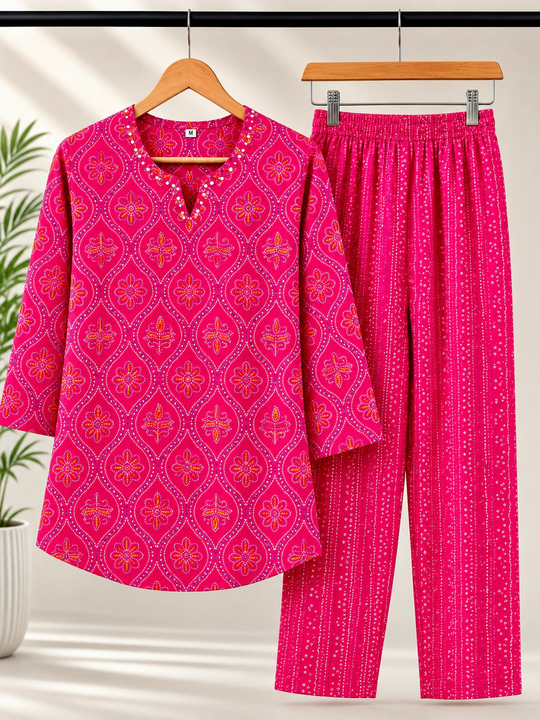 Rani pink bandhani coord set on hanger showing kurti and pants together