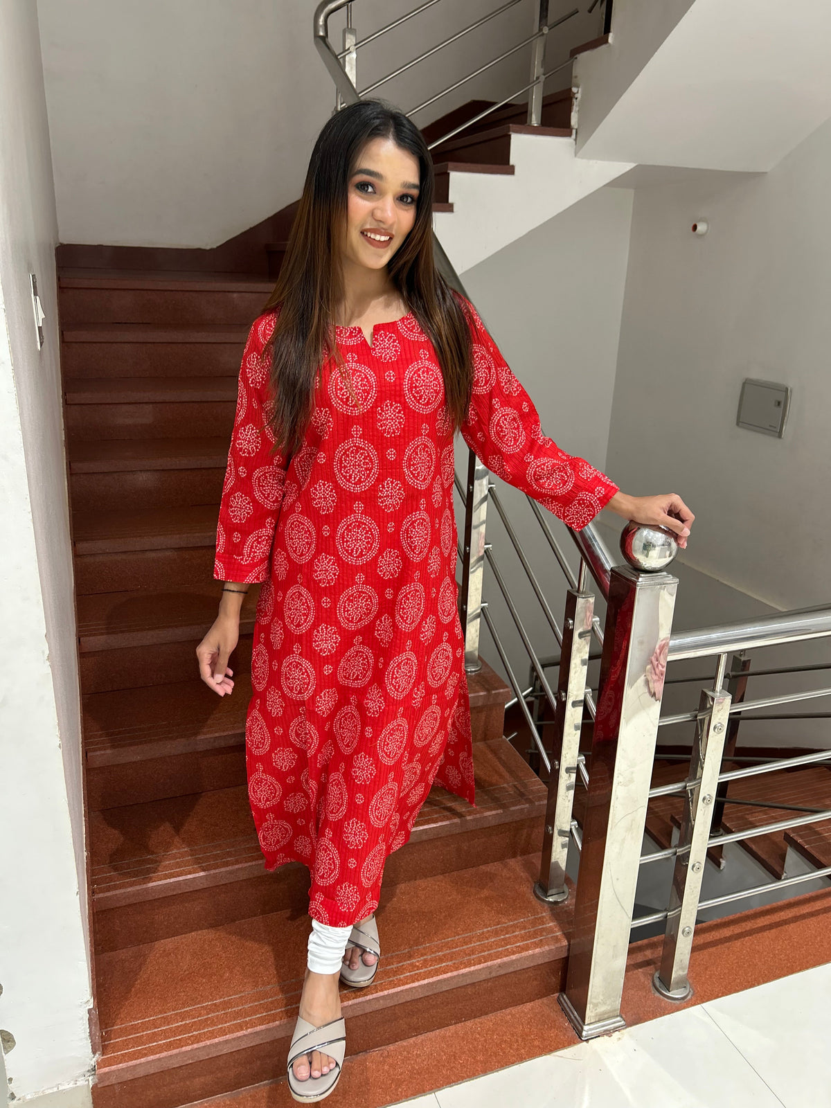 Model wearing red bandhani print cotton kurti on stairs