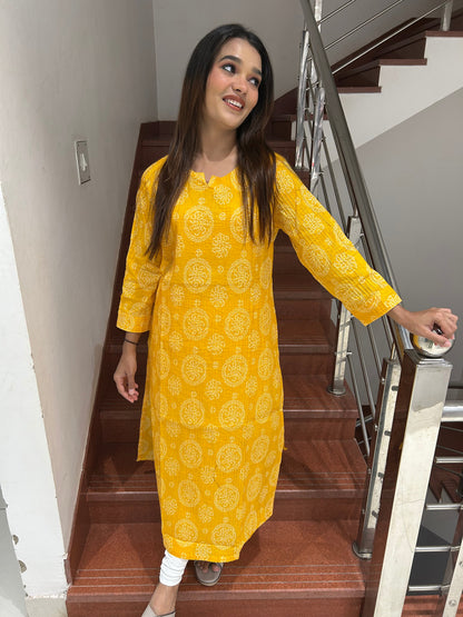 Model wearing yellow bandhani print cotton kurti on stairs